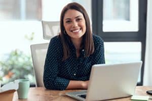 mujer frente a ordenador sonriendo